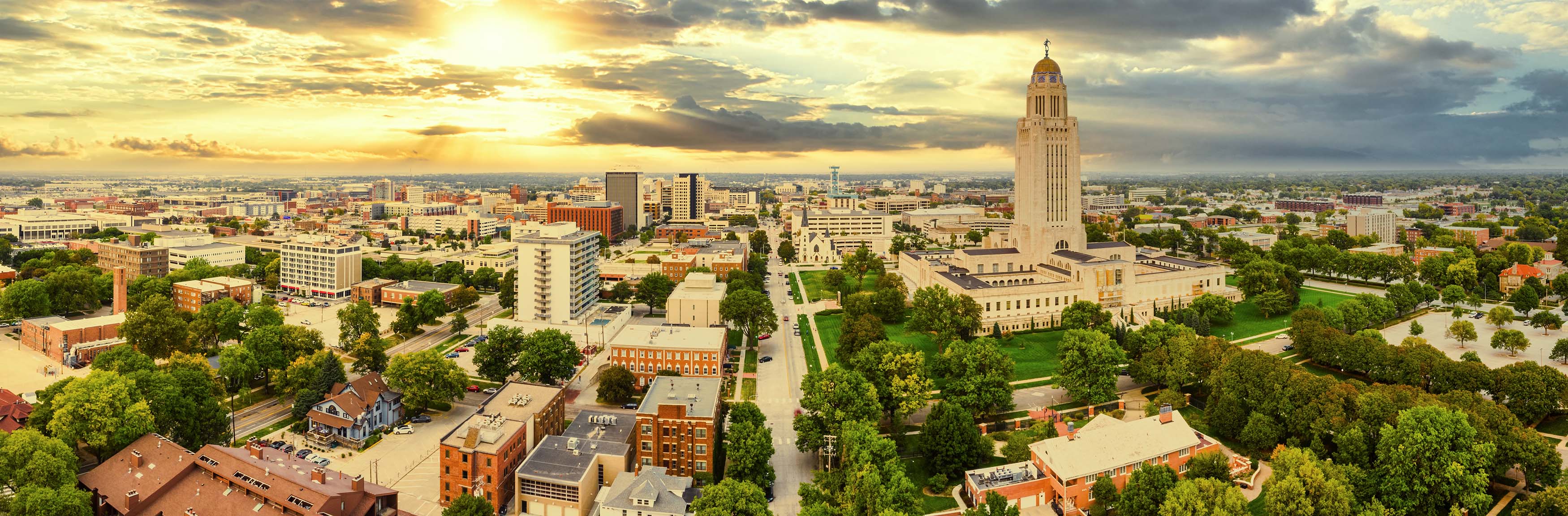 An image of a city skyline with the sun beginning to set overhead